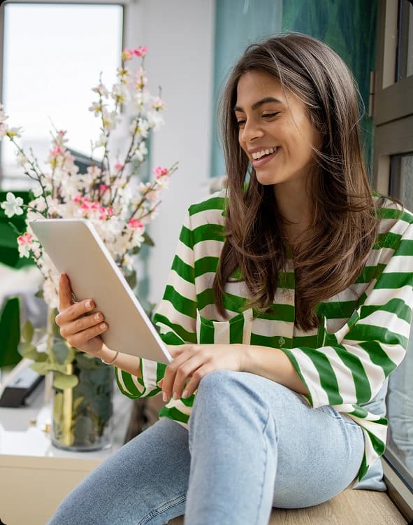 Mujer sonriendo mientras usa una tablet